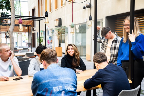 Studenten aan grote tafel aan het kletsen