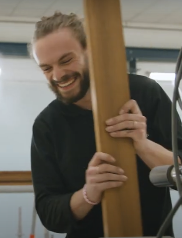 Creatief vakman houdt houten balk vast
